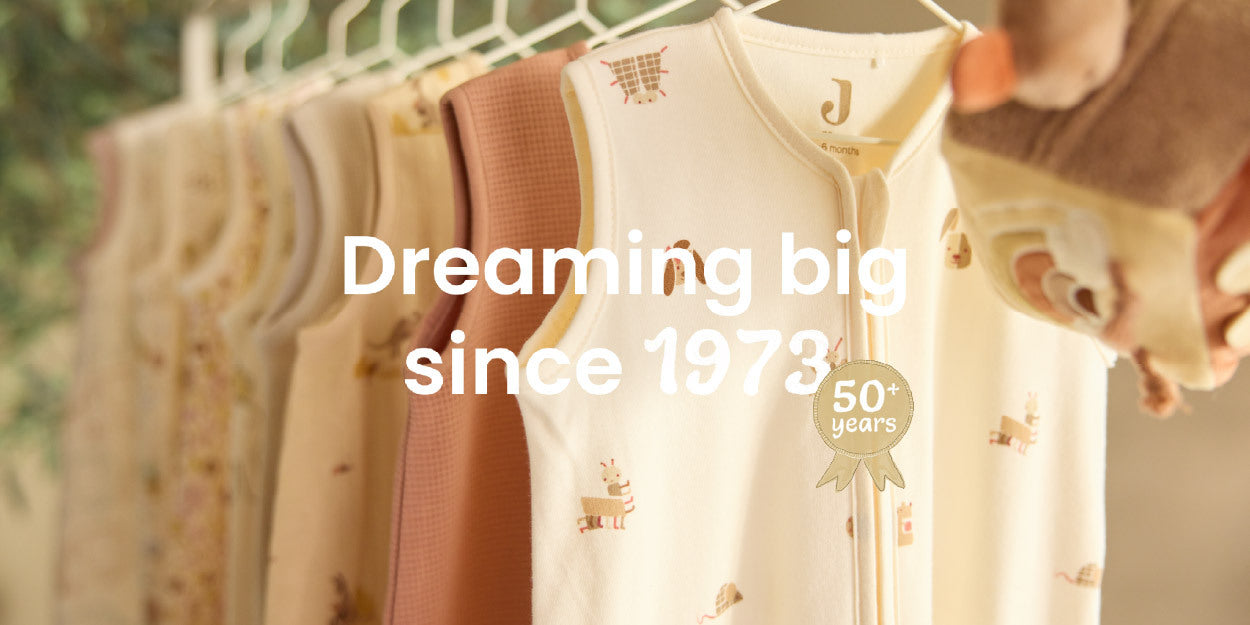 Baby Sleeping Bags hanging on a line with text 'Dreaming big since 1973' and '50+ years experience'.